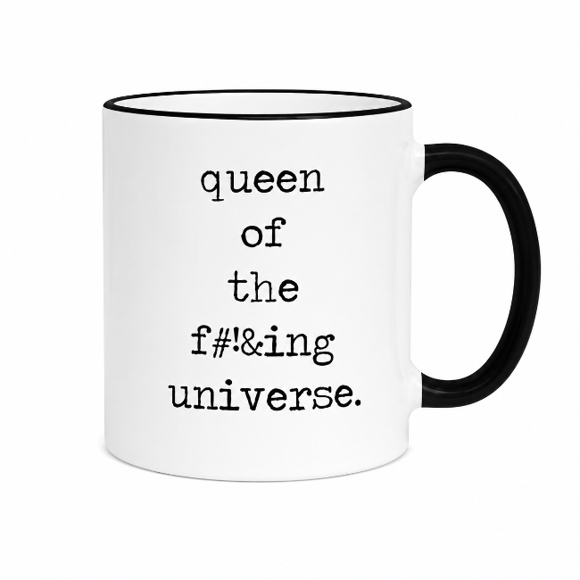 A white ceramic coffee mug with a black handle and black rim, featuring the text 'queen of the f#*&ing universe.' printed in a black typewriter-style font on the front.