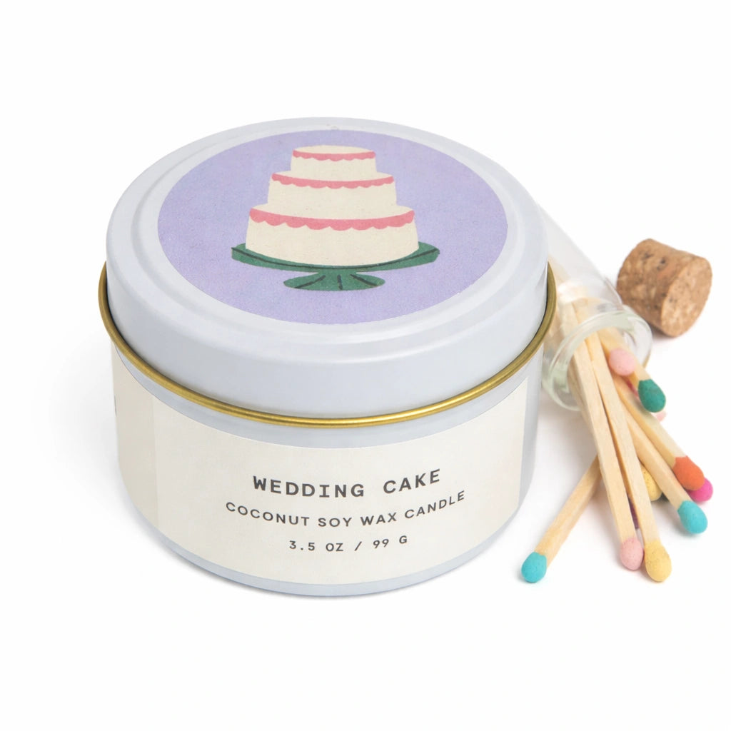 Candle in a tin with a wedding cake design on the lid, accompanied by matches.