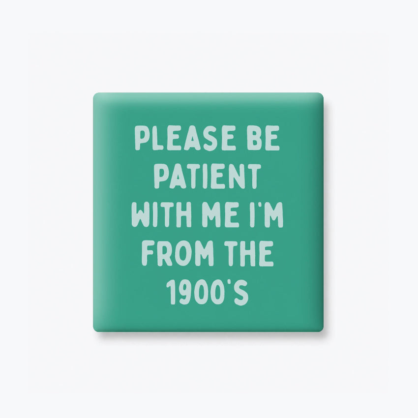 A square mint green button or badge with rounded corners, featuring the text 'PLEASE BE PATIENT WITH ME I'M FROM THE 1900's' in white hand-drawn style lettering, shown on a light gray background.