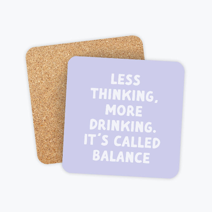 Two square cork coasters with rounded corners, one in front of the other. The front coaster is light lavender with white text reading 'LESS THINKING, MORE DRINKING.