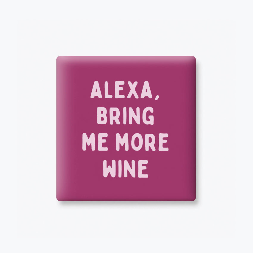 A square magenta button or badge with rounded corners featuring the text 'ALEXA, BRING ME MORE WINE' in light pink lettering, shown on a light gray background.