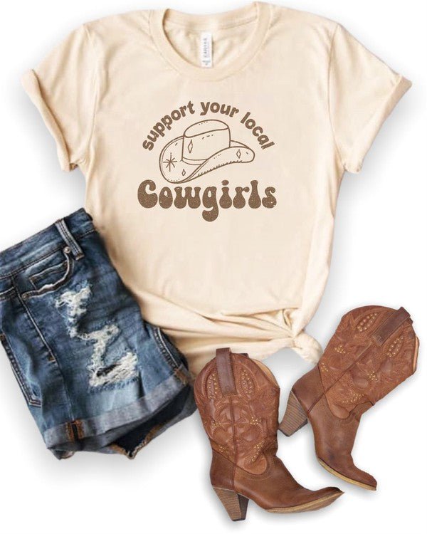 Beige t-shirt with 'Support your local cowgirls' text, denim shorts, and brown cowboy boots on a white background